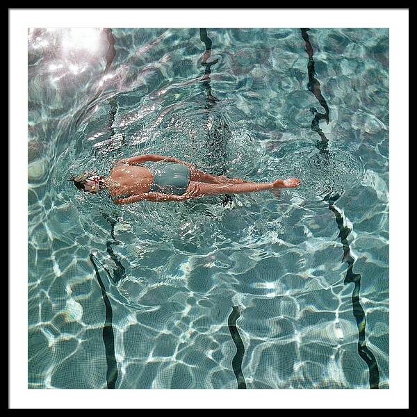 Woman Floating in Sunlit Pool Framed Print
